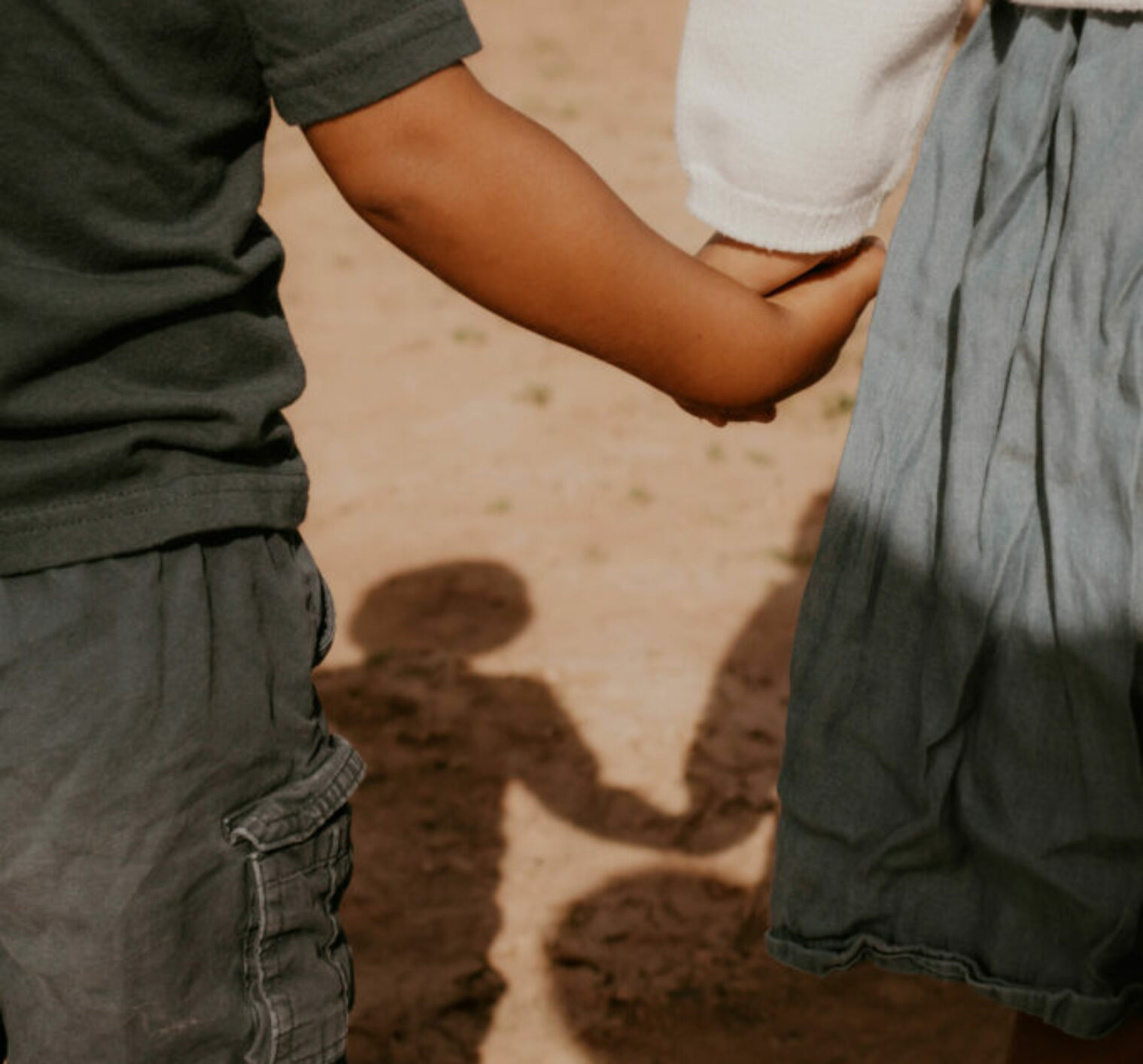 Zoom view of the hands of a little boy and girl as they hold hands